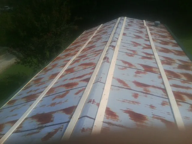 Rusted metal roof panels with new wood purlins before replacement — Storm Damage Roof Repair in Lincolnville by Roofing Brothers