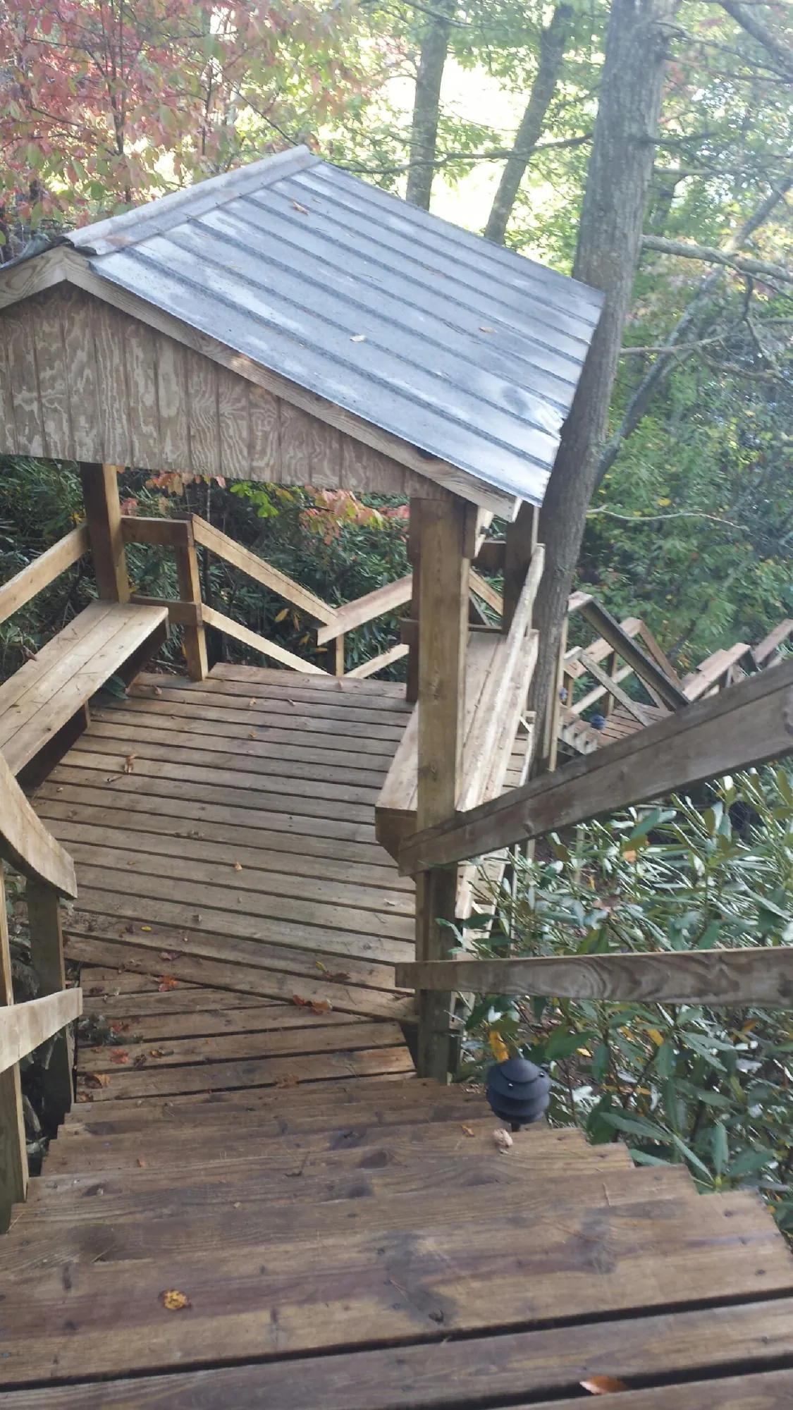 Metal roofed shelter over wooden steps on a wooded walkway — Skylight Repair & Installation work by our crew in Lincolnville